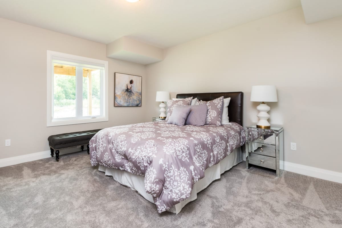 Large finished basement bedroom in a Meadowlily model home. Finished in soft tones.