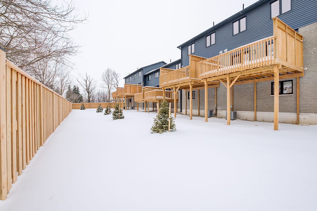 Backyard of House with Wooden Fence and Patio Balcony in Winter